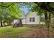 Backyard features a grassy lawn, shaded by mature trees, and a wooden deck leading to the house at 2860 Jefferson St, Austell, GA 30106