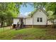A quaint home showcases its backyard with verdant lawn and mature trees offering shade and privacy at 2860 Jefferson St, Austell, GA 30106