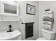 This bathroom features a toilet, sink with cabinet, mirror and towel rack on the wall, and neutral paint at 2860 Jefferson St, Austell, GA 30106