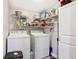 The laundry room features both a washer and dryer with shelving above and to the side for storage at 2860 Jefferson St, Austell, GA 30106
