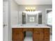 Bright bathroom with a double vanity, wood cabinetry, modern lighting fixture, and a large mirror at 4810 Habersham Se Way, Conyers, GA 30094