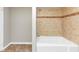 Bathroom showcasing tub with tiled walls and bronze accent border at 4810 Habersham Se Way, Conyers, GA 30094