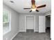 Bedroom with a window and closet entrance, featuring neutral walls, plush carpeting, and ceiling fan at 4810 Habersham Se Way, Conyers, GA 30094