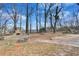 A spacious backyard with a stone outdoor fireplace and brick fire pit at 5774 Forest Dr, Acworth, GA 30102