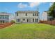 Expansive backyard with lush green lawn, wooden fence, and a covered patio area with a swing at 153 Towey Trl, Woodstock, GA 30188