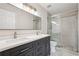 Bathroom featuring a double vanity, large mirror, and a tiled shower with glass door at 153 Towey Trl, Woodstock, GA 30188