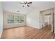 Bright bedroom with hardwood floors, ceiling fan, and natural light streaming in from the windows at 153 Towey Trl, Woodstock, GA 30188