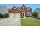 Charming two-story brick home features a well-manicured lawn and attached two-car garage at 153 Towey Trl, Woodstock, GA 30188