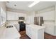 Well-appointed kitchen with stainless appliances, white cabinets, and island, blends style with functionality at 153 Towey Trl, Woodstock, GA 30188