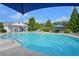 Enjoy the community pool with bright blue water, lounge chairs, and shade umbrellas for relaxation at 153 Towey Trl, Woodstock, GA 30188