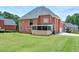 Expansive backyard features a covered porch area and leads out to a vast, grassy lawn at 240 Flowers Cove Ln, Lilburn, GA 30047