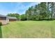 Spacious backyard with a lush green lawn and access to a detached garage, perfect for outdoor enjoyment at 240 Flowers Cove Ln, Lilburn, GA 30047