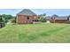 Extensive lawn in the backyard, offering ample space, a covered porch, and access to the detached garage at 240 Flowers Cove Ln, Lilburn, GA 30047