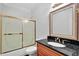 Bathroom features a granite countertop, decorative framed mirror, and glass sliding shower doors at 240 Flowers Cove Ln, Lilburn, GA 30047