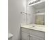 Bathroom vanity with white cabinets, a large mirror, and modern lighting at 240 Flowers Cove Ln, Lilburn, GA 30047
