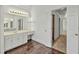 Bathroom vanity with marble countertops, white cabinets and tile floors at 240 Flowers Cove Ln, Lilburn, GA 30047
