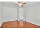A bright bedroom with hardwood floors, white trim, and an open doorway at 240 Flowers Cove Ln, Lilburn, GA 30047