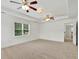 Spacious carpeted bedroom featuring tray ceilings, ceiling fans, and a window offering natural light at 240 Flowers Cove Ln, Lilburn, GA 30047