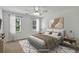 Well-lit bedroom with a neutral color palette, large windows, and cozy decor at 240 Flowers Cove Ln, Lilburn, GA 30047