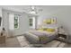 Bright staged bedroom features plush carpeting, modern ceiling fan, and natural light from the two windows at 240 Flowers Cove Ln, Lilburn, GA 30047