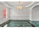 Formal dining room featuring white walls, a modern chandelier, marble floors, and natural light, creating an elegant and inviting space at 240 Flowers Cove Ln, Lilburn, GA 30047
