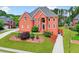 Charming two-story brick home boasts a lush lawn, mature trees, and inviting curb appeal at 240 Flowers Cove Ln, Lilburn, GA 30047