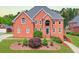 Impressive red brick home with manicured landscaping, a multi-car driveway, and a stately entrance at 240 Flowers Cove Ln, Lilburn, GA 30047