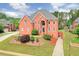 Impressive red brick home with manicured landscaping, a multi-car driveway, and a stately entrance at 240 Flowers Cove Ln, Lilburn, GA 30047