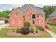 Beautiful brick home featuring lush landscaping, a well-maintained lawn, and a welcoming entrance at 240 Flowers Cove Ln, Lilburn, GA 30047