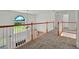Carpeted hallway with wood railings and a view to the front yard at 240 Flowers Cove Ln, Lilburn, GA 30047