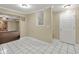 Open hallway with tiled floors leads to basement with wall art and recessed lights at 240 Flowers Cove Ln, Lilburn, GA 30047