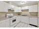 Efficient kitchen with white appliances, countertops, cabinetry, and tiled floor at 240 Flowers Cove Ln, Lilburn, GA 30047