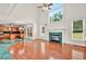 Open-concept living space with hardwood floors, fireplace and large windows offering plenty of natural light into the home at 240 Flowers Cove Ln, Lilburn, GA 30047