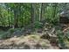 Backyard featuring a stone patio with wooden chairs, surrounded by lush greenery at 2819 Saddlebrook Nw Way, Marietta, GA 30064
