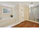Luxurious bathroom with soaking tub, separate shower, and decorative glass block window at 2819 Saddlebrook Nw Way, Marietta, GA 30064