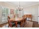 Bright dining room with chandelier, wooden table, and shuttered windows offering ample natural light at 2819 Saddlebrook Nw Way, Marietta, GA 30064