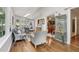 Bright sunroom featuring hardwood floors, wicker furniture, and views of the wooded yard at 2819 Saddlebrook Nw Way, Marietta, GA 30064