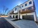 A townhome exterior with black garage doors and wood balcony off the first floor at 518 Healy Dr # 68, Cumming, GA 30040