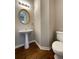 Powder room featuring a pedestal sink with an oval mirror, toilet, and hardwood floor at 690 Kimball Parc Way, Alpharetta, GA 30022