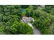 Aerial view showcasing a private estate surrounded by trees, featuring a pool and tennis court at 1430 N Harris Rdg, Atlanta, GA 30327