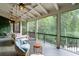 Inviting screened-in porch with a cozy swing, comfortable chairs, and views of the private, wooded backyard at 1430 N Harris Rdg, Atlanta, GA 30327