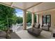 Covered outdoor patio with comfortable seating, a coffee table, and views of the backyard pool and lush greenery at 1430 N Harris Rdg, Atlanta, GA 30327