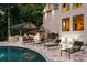 Backyard pool area featuring lounge chairs, an outdoor kitchen, and access to the home's interior at 1430 N Harris Rdg, Atlanta, GA 30327