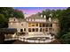 Luxury home's backyard featuring a pool, outdoor kitchen, multiple windows, and large patio at 1430 N Harris Rdg, Atlanta, GA 30327