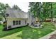 Lush backyard featuring a stone patio with seating, a firepit, and mature trees at 2633 Hanriva Ct, Dacula, GA 30019