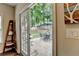 A backyard view through French doors, showcasing a brick patio and a lush, fenced green lawn at 2633 Hanriva Ct, Dacula, GA 30019