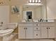 Bathroom with double sinks, white cabinetry, a large mirror, and a painting of birds at 2633 Hanriva Ct, Dacula, GA 30019