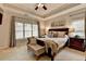 Cozy bedroom with tray ceilings, large window, bench seat, and bedside table at 2633 Hanriva Ct, Dacula, GA 30019