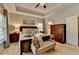 Comfortable bedroom with tray ceilings, large window, bench seat, and dark wood furnishings at 2633 Hanriva Ct, Dacula, GA 30019