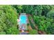 Aerial view of the community pool nestled among trees with ample seating and a pristine, inviting atmosphere at 2633 Hanriva Ct, Dacula, GA 30019